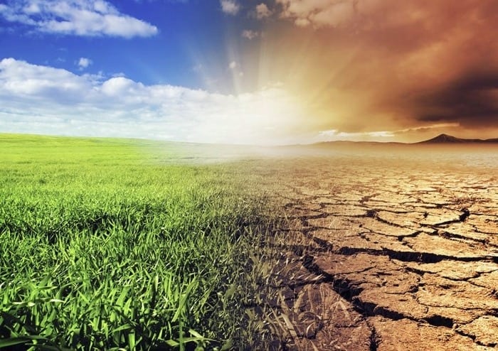 Contraste entre l'herbe verte, le ciel bleu, la terre sèche et le ciel pollué