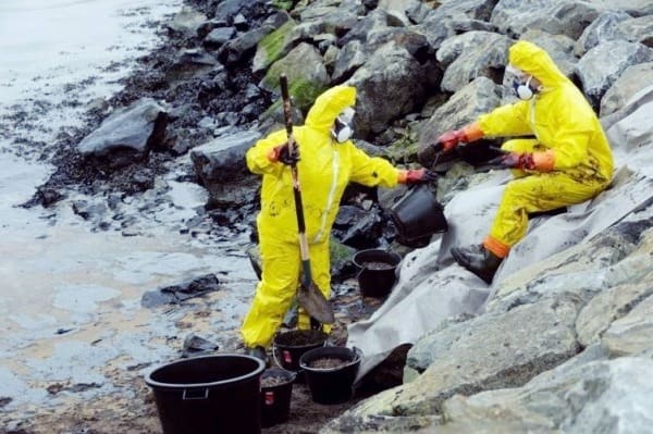 Deux scientifiques en costume nettoient la côte de la pollution